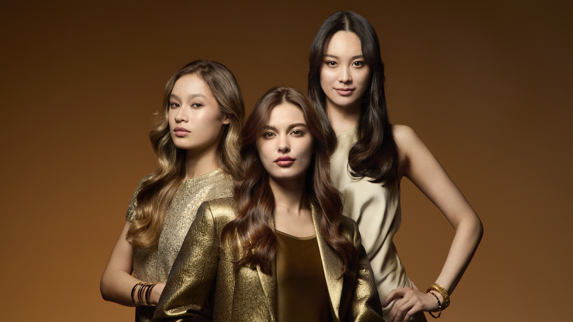 ゴールドの服を着たULTIMEのモデルが3人立っている