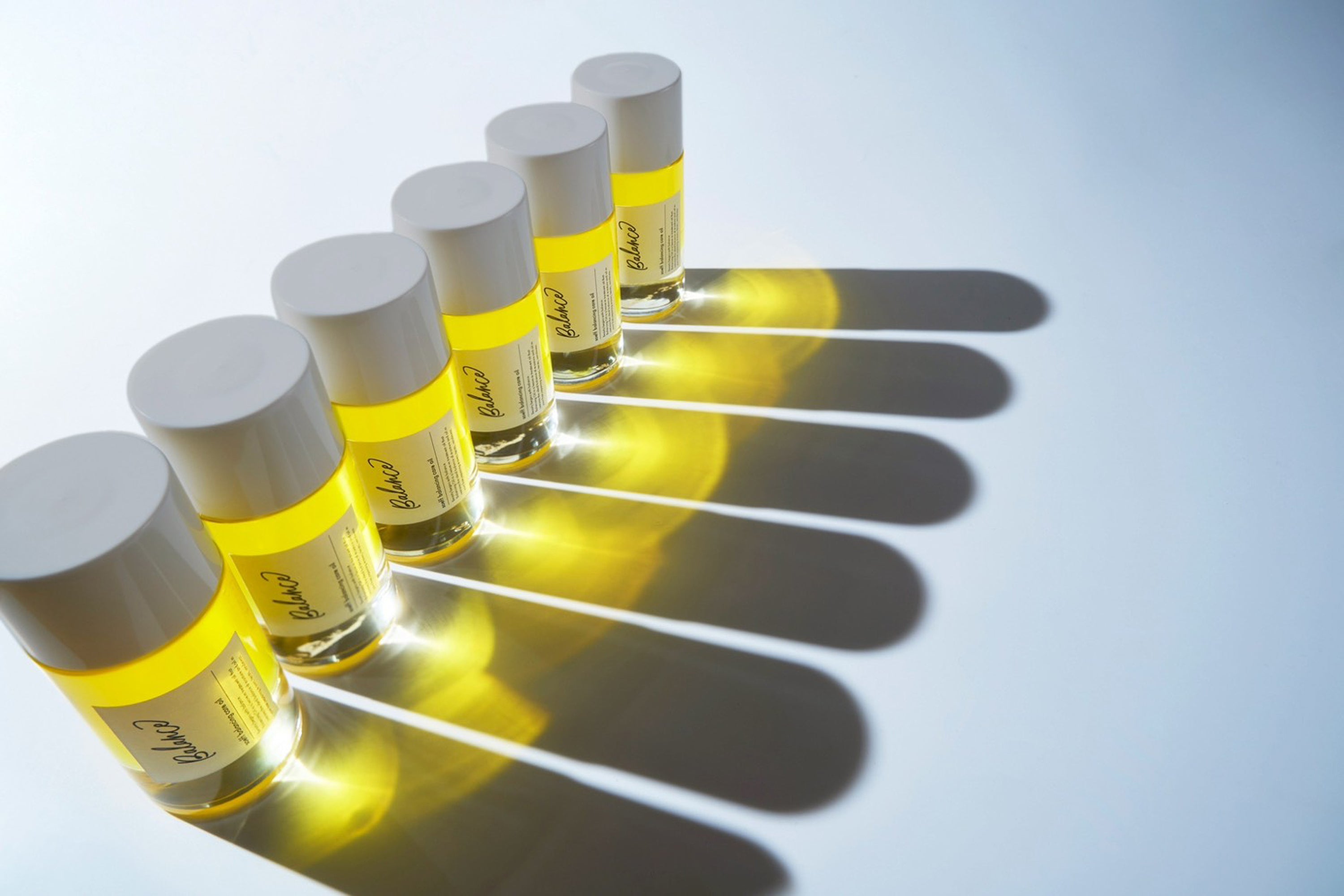 soeff バランシングケアオイルが6つ横並びに置かれていて後ろから強い光が当てられているため影が大きく伸びている。